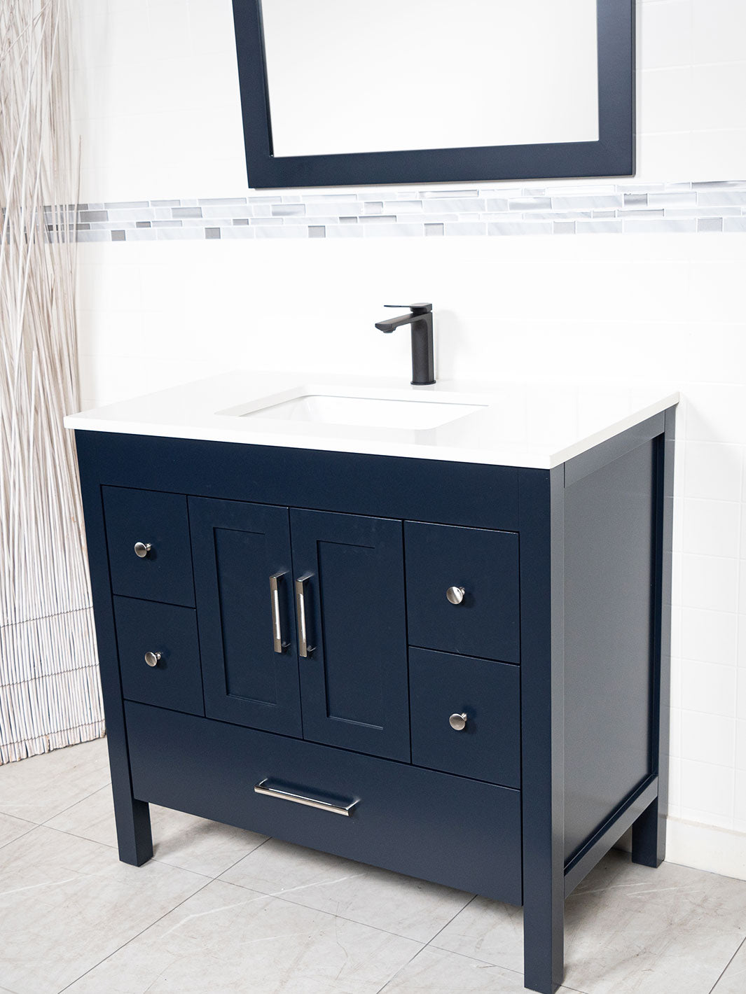 Blue bathroom vanity with white counter, black faucet