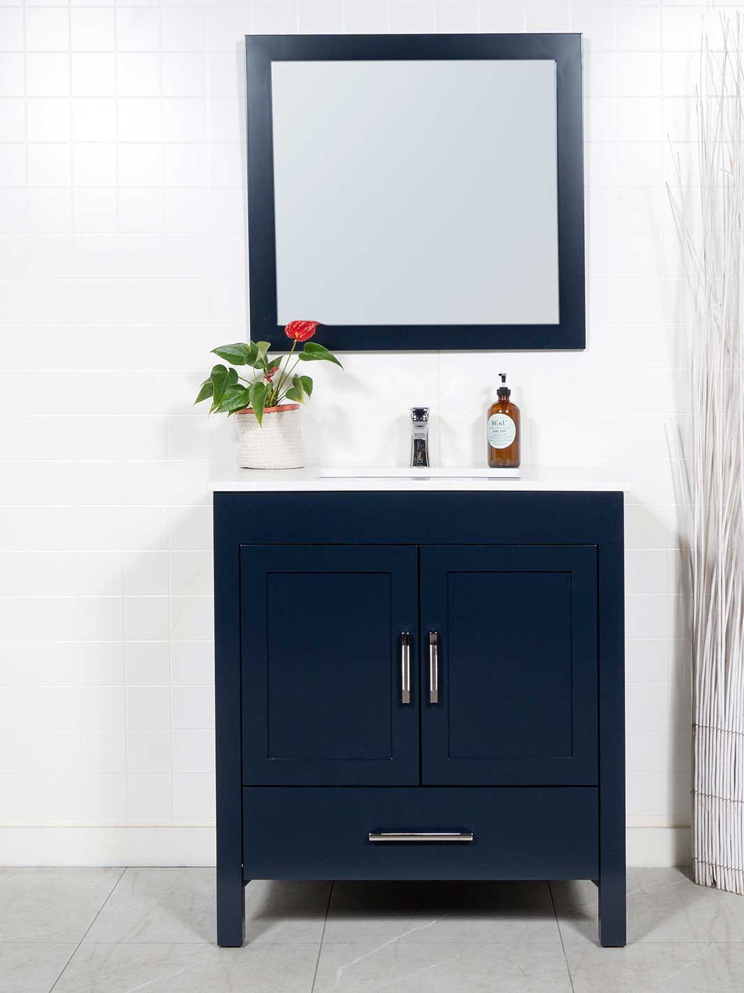 Blue bathroom vanity with white quartz counter and matching blue framed mirror