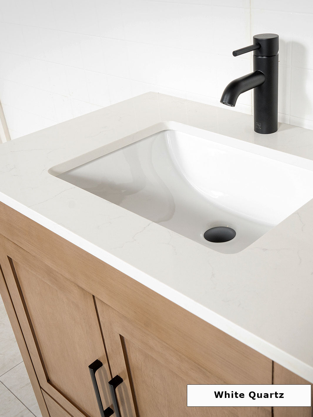 white quartz counter on the white oak vanity. black round faucet