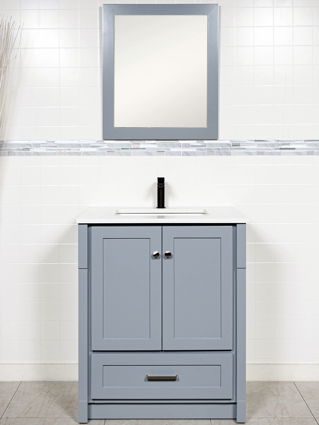 grey vanity with kickboard, grey framed mirror, white quartz counter, and chrome faucet
