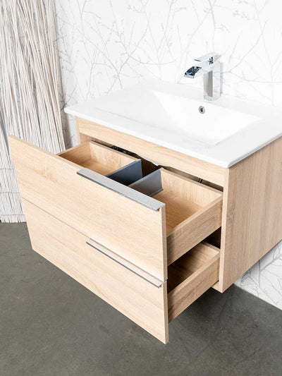 Two drawers open on wood grain finish vanity. White ceramic sink and chrome faucet.