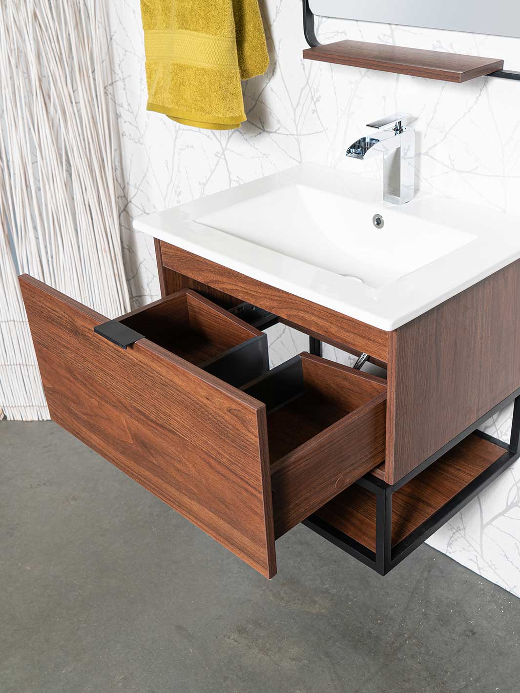 Drawer beneath sink and bottom shelf of floating style vanity with wood grain finish