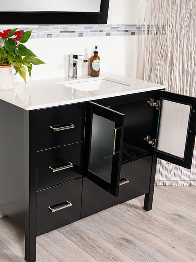 black vanity, cupboard beneath sink with frosted glass doors