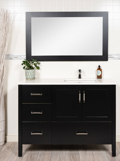 black vanity with sink on the right. drawers on the left. matching mirror