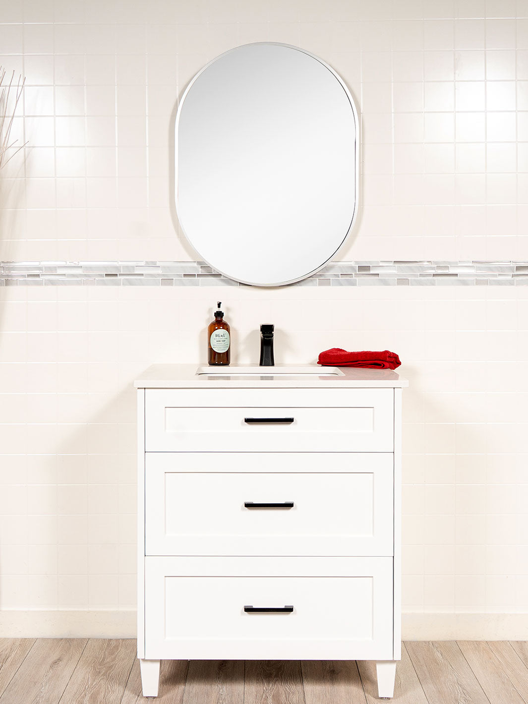 white vanity with drawers, oval mirror, black hardware