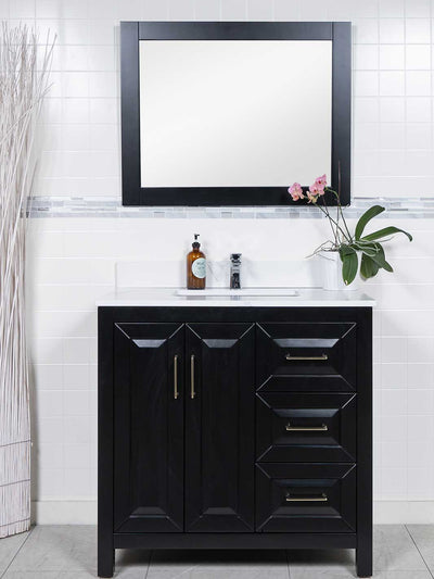 Black vanity with 3 drawers on the right. White counter. black framed mirror
