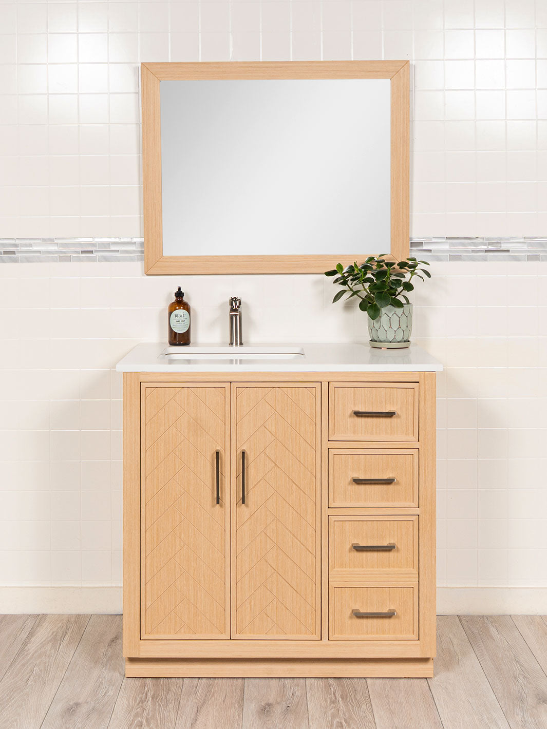 light oak vanity with herringbone, white quartz counter, matching wood framed mirror