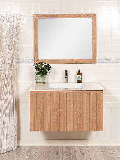 floating vanity, reeded drawer, sintered stone counter, faucet and wood framed mirror