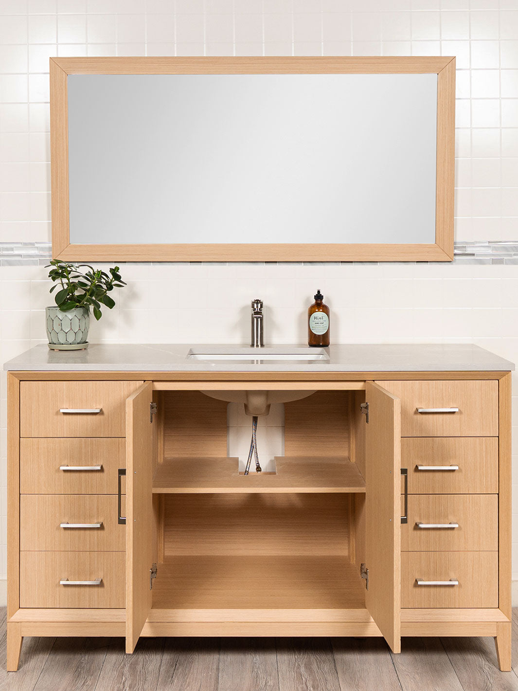 cabinet doors open beneath sink showing shelf and a cut out for the drain
