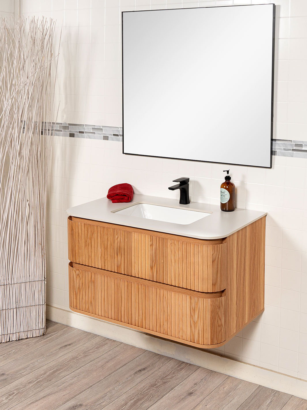 reeded floating vanity. black faucet. white sintered stone counter