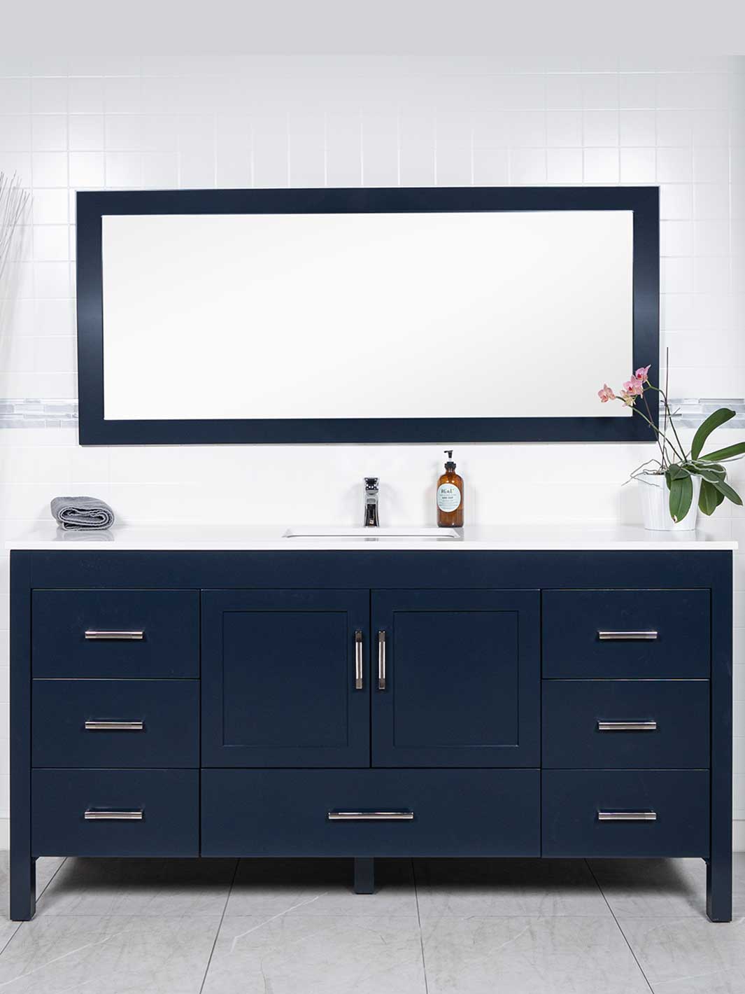 Blue bathroom cabinet and matching blue mirror. White quartz countertop