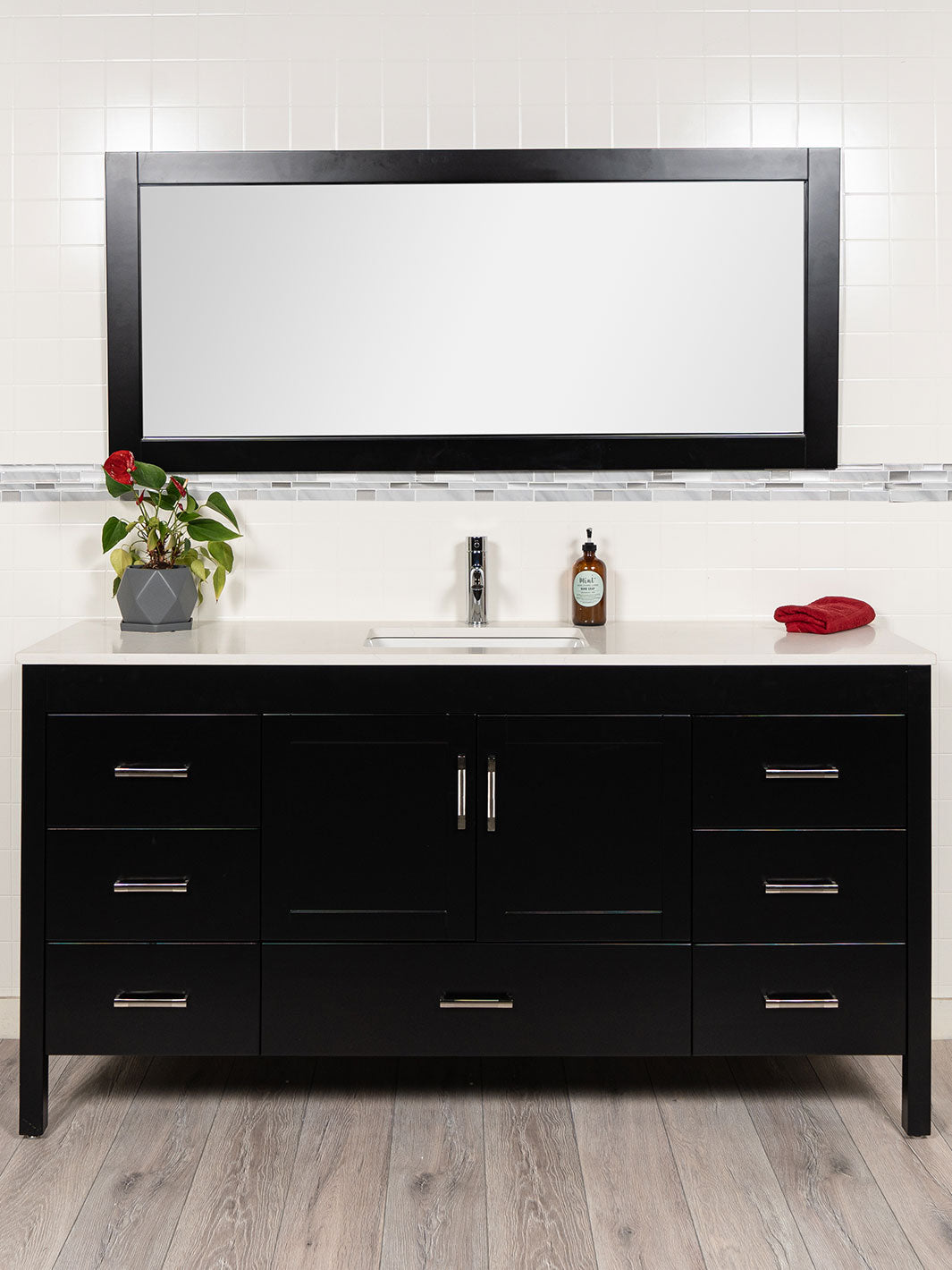 large black bathroom vanity with matching black mirror. white quartz counter