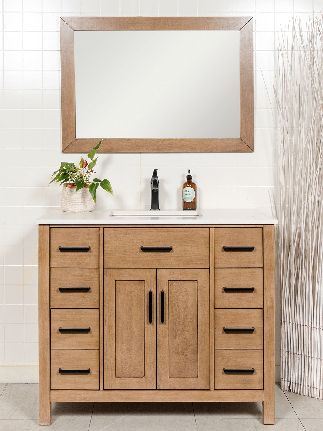 white oak bathroom vanity with matching framed mirror, quartz counter, black faucet and door pulls