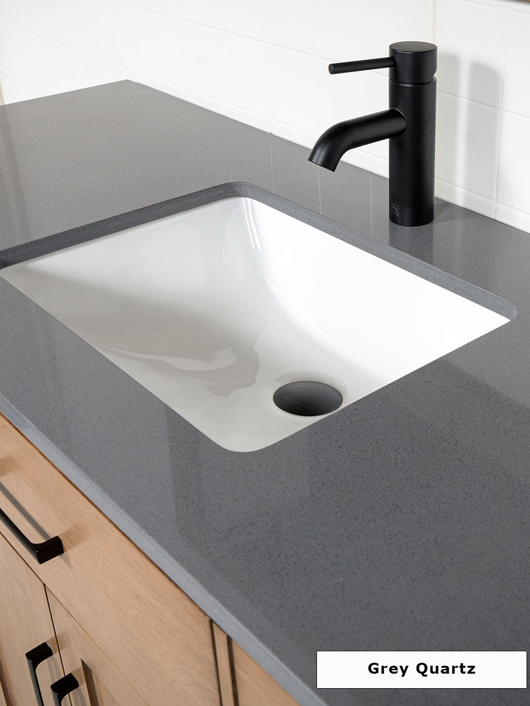 grey quartz counter with attached undermount sink and matte black faucet
