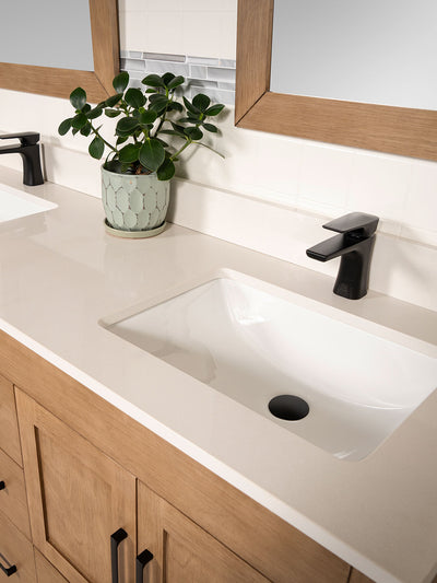 white quartz counter with attached sinks. black faucet