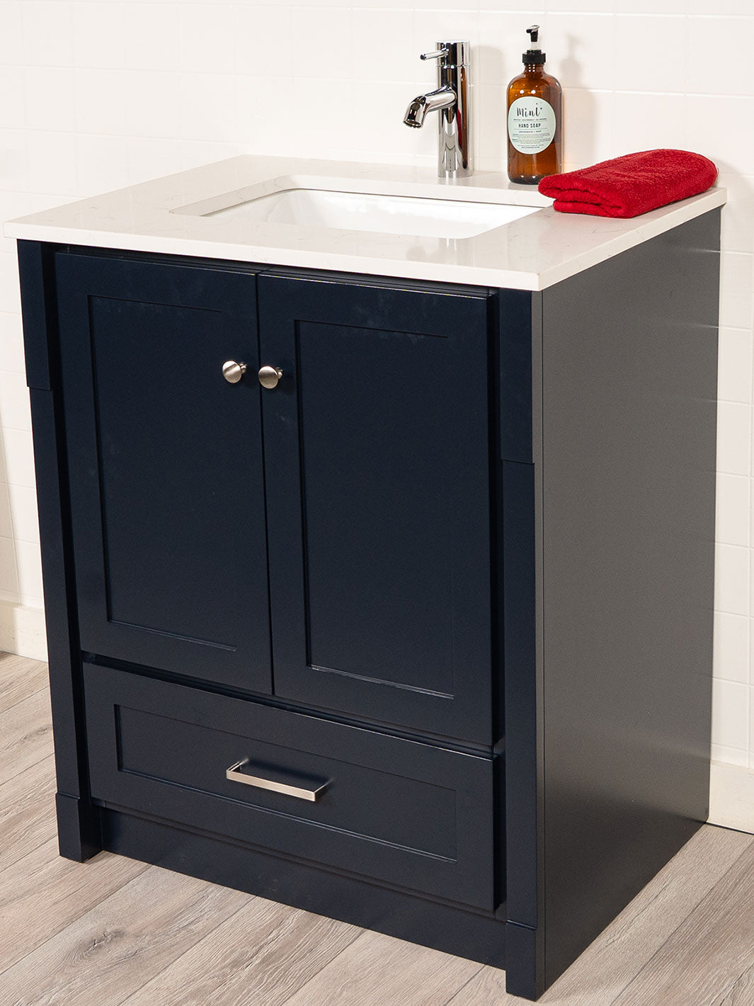 Blue bathroom cabinet, chrome pulls, and faucet