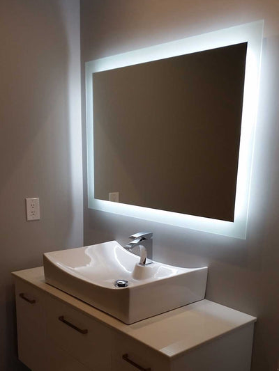 LED backlit mirror installed over a vanity