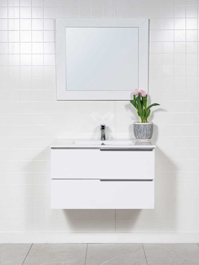White floating vanity with two drawers, white ceramic sink, chrome faucet and white framed mirror