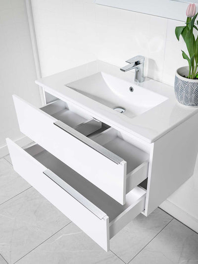 White floating vanity with two drawers, white ceramic sink, and chrome faucet