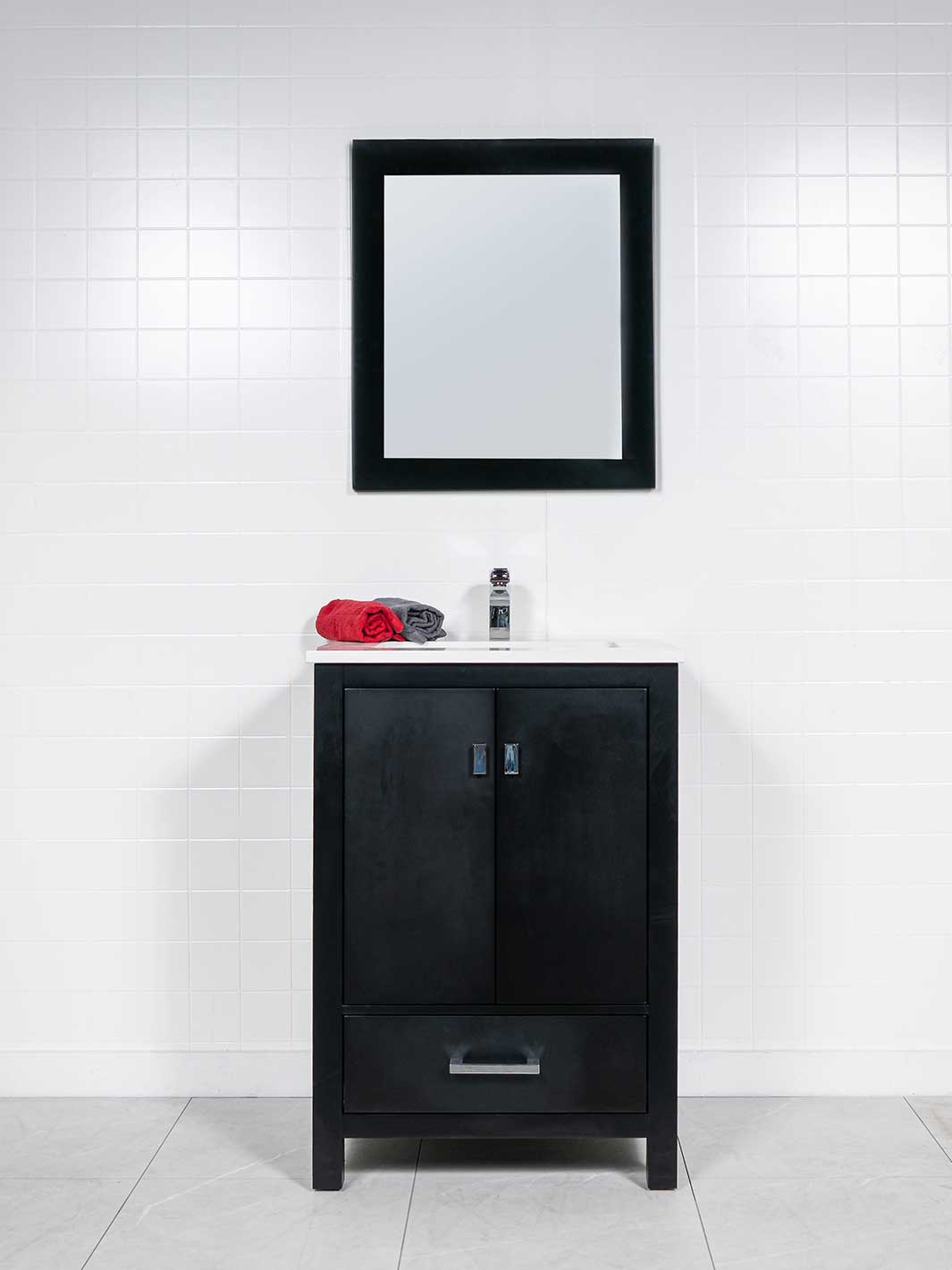 black vanity with white quartz counter, black framed mirror, and chrome faucet